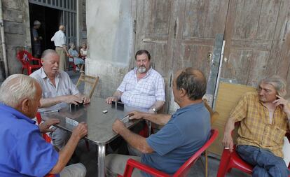 Vecinos de Valencia juegan al domin&oacute; sentados a la fresca. 
