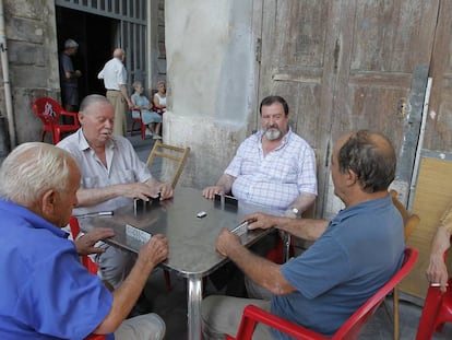 Vecinos de Valencia juegan al domin&oacute; sentados a la fresca. 