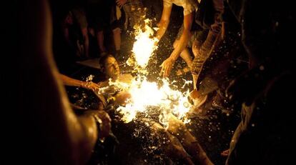Varias personas intentan apagar las llamas del manifestante que se prendió fuego.