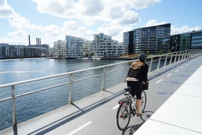 Una mujer pedalea por un puente solo para bicis en Copenhague.