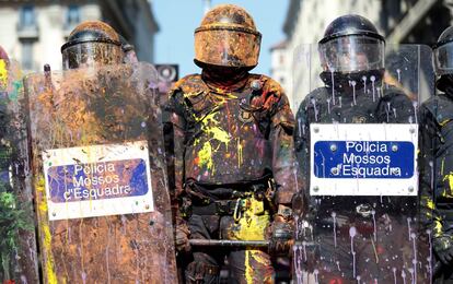 Agentes de los Mossos cubiertos de pintura después de enfrentarse con manifestantes.