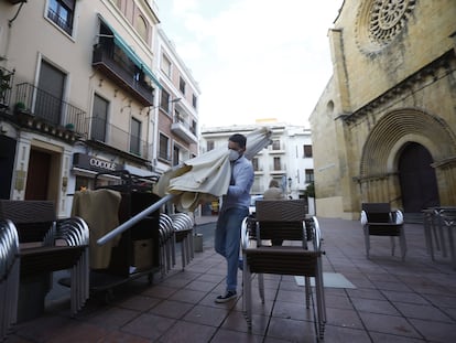 Un trabajador recoge el mobiliario de la terraza de un restaurante en el centro de Córdoba.EFE/Salas