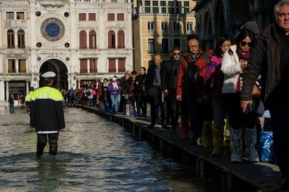 El Consejo de Ministros del Gobierno italiano, que se celebra este jueves, aprobará el estado de emergencia en Venecia, tras sus mayores inundaciones desde 1966. En la imagen, la gente camina por una pasarela improvisada sobre la inundada plaza de San Marcos, en Venecia.