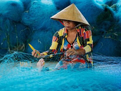 Una mujer repara redes de pesca en el delta del río Mekong, en Vietnam.