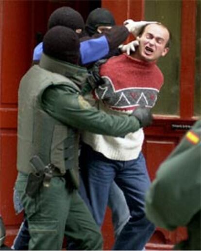 Agentes de la Guardia Civil sacan a uno de los detenidos de su domicilio, situado en la Calle del Carmen de Pamplona.