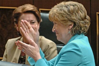 La ministra de Educación y Ciencia, María Jesús San Segundo (dcha.), charla con la titular de Fomento, Magdalena Alvárez, durante el pleno del Congreso celebrado hoy.