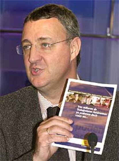 El coordinador del programa electoral del PSOE, Jesús Caldera, sostiene el folleto de la campaña publicitaria.