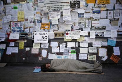 Uno de los acampados duerme en la Puerta del Sol cuando se cumplen 10 días de acampada.