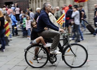 Un padre con su hija en bicicleta camino de la cadena humana en Barcelona.