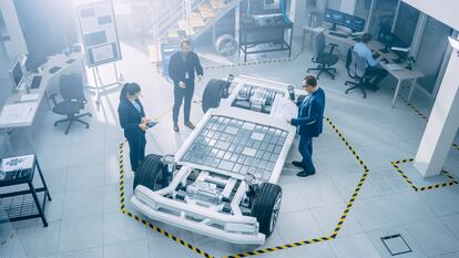 Un equipo de ingenieros trabaja en un prototipo de chasis de coche eléctrico.