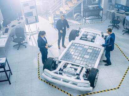 Un equipo de ingenieros trabaja en un prototipo de chasis de coche eléctrico.