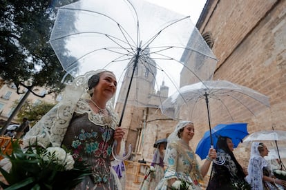 Falleras desfilan con paraguas durante la ofrenda de flores a la Virgen de los Desamparados este martes, durante las Fallas de Valencia.