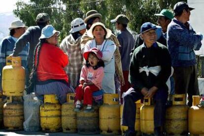 Un grupo de personas espera la llegada del camión de gas en la autopista que une la ciudad de La Paz con la ciudad de El Alto.