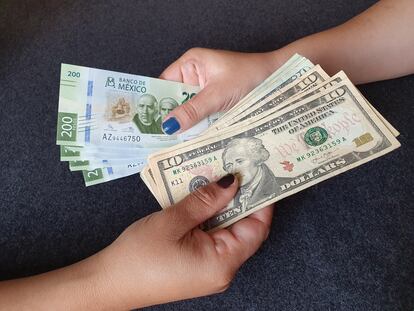 Una mujer intercambia dólares por pesos mexicanos.
