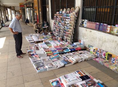 Frente a la estación de tren de la ciudad, los vendedores de periódicos despliegan su arsenal de papel sobre las baldosas del suelo.