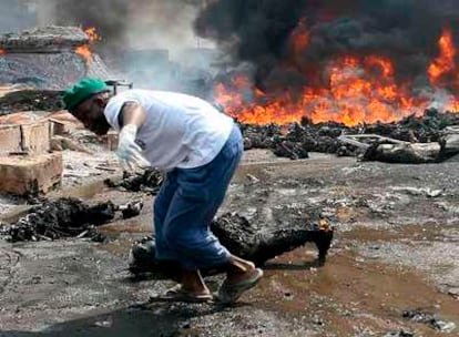 Un miembro del equipo de rescate arrastra los restos de un cuerpo quemado ayer cerca de Lagos, la capital económica de Nigeria.