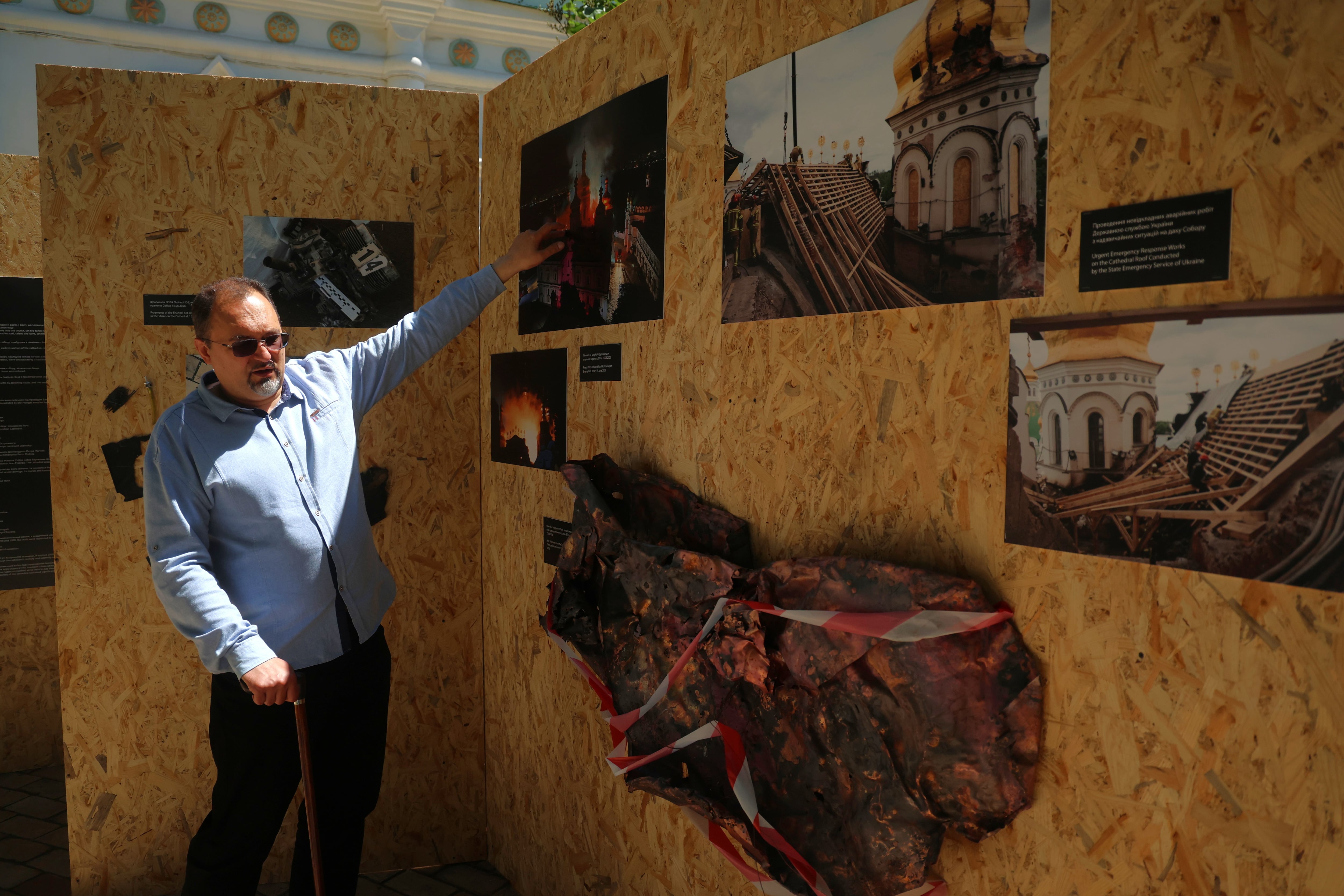 El historiador Kostiantyn Krainii, subdirector del complejo que acoge al Monasterio de las Cuevas de Kiev, junto a restos del ataque del 15 de junio.