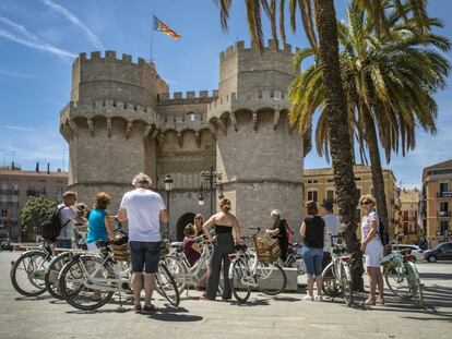 Un grupo de ciclistas en Valencia, frente a las Torres de Serranos. 