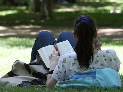 Una mujer lee en el parque del Retiro de Madrid, donde se celebra la Feria del Libro.