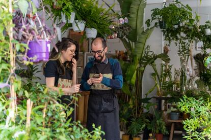 Javier Lapuerta, uno de los tres dueños de la tienda Plantas luego existes, atendiendo a una clienta