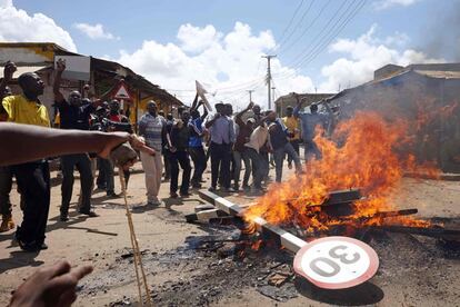 Partidarios del partido opositor Kenia National Super Alliance (NASA) reaccionan detrás de una barricada durante una manifestación en Soweto Slum, cerca de Jacaranda Ground en Nairobi, donde el líder de la NASA estaba destinado a llevar a cabo un servicio en memoria de los asesinados en demostraciones recientes.