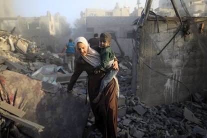 Una mujer huye con un niño durante un ataque aéreo en el campo de refugiados de al-Maghazi, en el centro de la franja de Gaza.