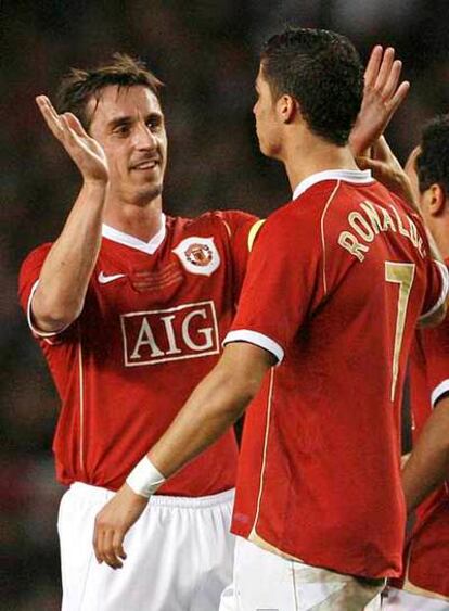 Cristiano Ronaldo celebra con Gary Neville uno de sus goles en el partido de este martes en Old Trafford.