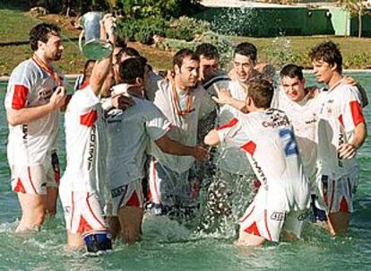 Los jugadores del Ademar mojan su alegría en la fuente del Pabellón Infanta Cristina de Torrevieja.