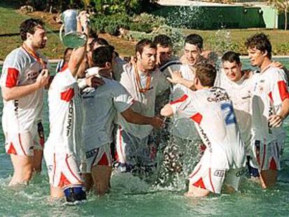 Los jugadores del Ademar mojan su alegría en la fuente del Pabellón Infanta Cristina de Torrevieja.