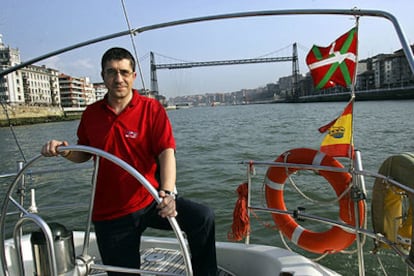 Patxi López, en la ría de Bilbao con el puente colgante de su pueblo al fondo.