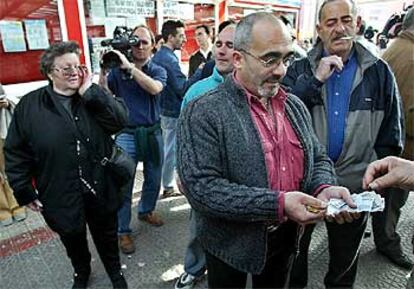 Conductores de autobuses en huelga recogen dinero en la estación de Bilbao para pagar un taxi a una mujer (a la izquierda) que se quedó sin billete.