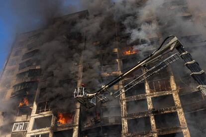 Un bombero intenta sofocar el incendio en un bloque de viviendas afectado por bombardeos de artillería en Kiev, este martes.