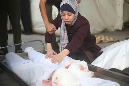 Una mujer llora junto al cadáver de dos bebes muertos tras los ataques israelíes en Rafah, al sur de la franja de Gaza.  