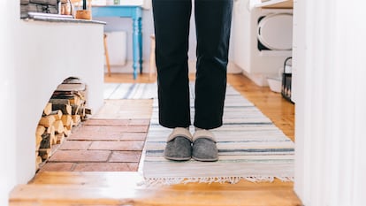 Una persona con Zapatillas calefactables en casa.