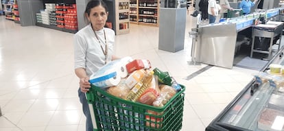 Paola, con un carro lleno de productos no perecederos como agua, pan, arroz, pasta, tomate, azúcar o huevos, este lunes, durante el apagón, en Barcelona.