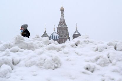 Una mujer camina entre una montaña de nieve en la plaza Roja de Moscú (Rusia). El país suministrará casi 6,5 millones de dosis de la vacuna Sputnik V a sus centros médicos en enero y febrero de 2021, según informó Mijaíl Mishustin, primer ministro del país.