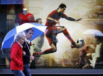 Una pareja pasea por delante de un escaparate con un anuncio de Cristiano Ronaldo.