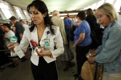 Una empleada de aeropuerto retira las cremas de una pasajera. En los vuelos con salida de Reino Unido o con destino a EE UU se ha prohibido introducir líquidos o geles como equipaje de mano.