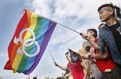 Un hombre porta la bandera arcoiris en una manifestaci&oacute;n en Taipei.