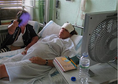 Una paciente combate las altas temperaturas en su habitación del Clínico con un ventilador, gasas húmedas y la ayuda de un familiar.