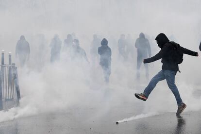 La gente camina en un humo durante una protesta contra la cadena de reformas del gobierno francés, en París.