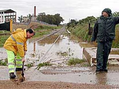 Un operario trataba ayer de acondicionar la vía férrea a su paso por Alcolea del Río (Sevilla).