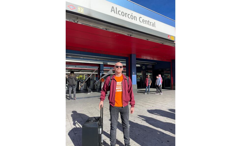 Adrián Espina, este domingo frente a la estación central de Alcorcón, con una camiseta naranja del Sindicato de Inquilinas e Inquilinos de Madrid y un altavoz.