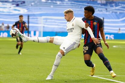 El defensa del FC Barcelona Alejandro Balde (a la derecha) pugna por el balón con el delantero del Real Madrid Fede Valverde.