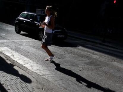 Una mujer cruza un paso de cebra, prácticamente borrado, en el centro de Valencia.