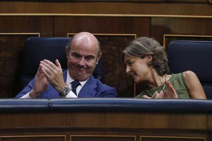 Los ministros en funciones de Economía, Luís de Guindos (i), y Agricultura y Pesca, Isabel García Tejerina (d), aplauden durante el discurso de investidura del presidente del Gobierno en funciones, Mariano Rajoy.