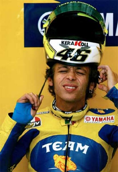 Valentino Rossi trata de ponerse el casco hoy en Assen con su muñeca fracturada.