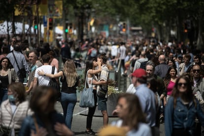 Una pareja se besa entre la gente en el paseo de Gràcia.