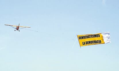 <b>Uno de los participantes en la protesta del Movimiento 15-M, sujetando una pancarta en la Puerta del Sol.</b>