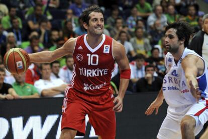 El turco Tunceri controla el balón ante el serbio Milos Teodosic durante el partido Serbia-Turquía.